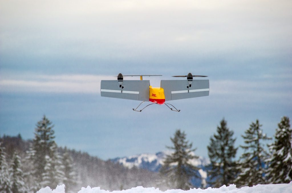 Ein kleines Kippflügelflugzeug landet dann mit der nächsten Paketladung und nimmt Pakete mit, die DHL-Kunden zum Verschicken deponiert haben. (#05)